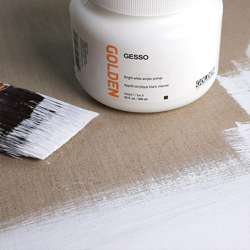 An open white gesso tub with a paintbrush on a can
